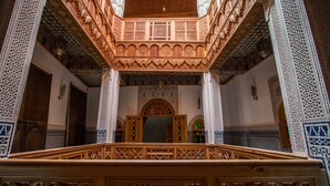 An ornate interior with intricate wooden carvings and detailed tile work. - Riad Al Fassia Palace (Fes)