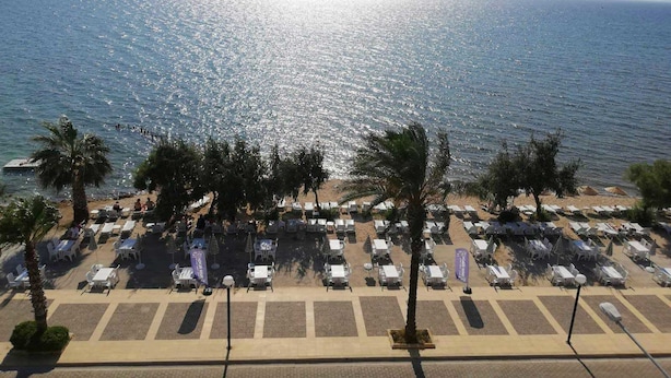 Un hotel frente a la playa con zonas de estar al aire libre y vistas al mar.