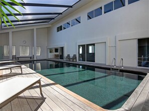 Una piscina cubierta, tumbonas