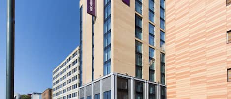 A modern building with multiple floors, large windows, and a prominent Premier Inn sign.