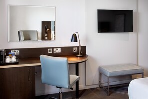 A hotel room with a desk, chair, bedside table, bench, and a TV mounted on the wall. - Premier Inn Bridlington Seafront (Bridlington)