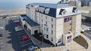 A hotel with multiple floors, a parking lot, and a view of the beach. - Premier Inn Bridlington Seafront (Bridlington)