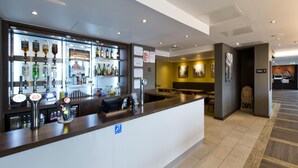 A hotel lobby with a bar area, seating, and a visible restroom sign. - Premier Inn Slough West - Slough Trading Estate (Slough)