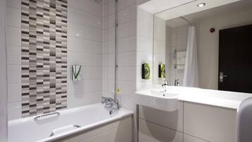 A modern bathroom with a freestanding bathtub, a large mirror, and a shower area.