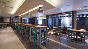 A modern restaurant with high tables, bar stools, and a variety of seating options. - Premier Inn Southampton - Cumberland Place (Southampton)