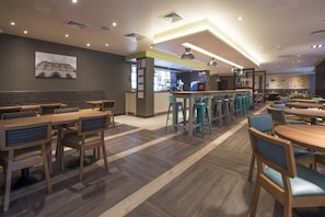 Un restaurant doté de plusieurs espaces de restauration, notamment des banquettes et des tables, un bar et un comptoir.