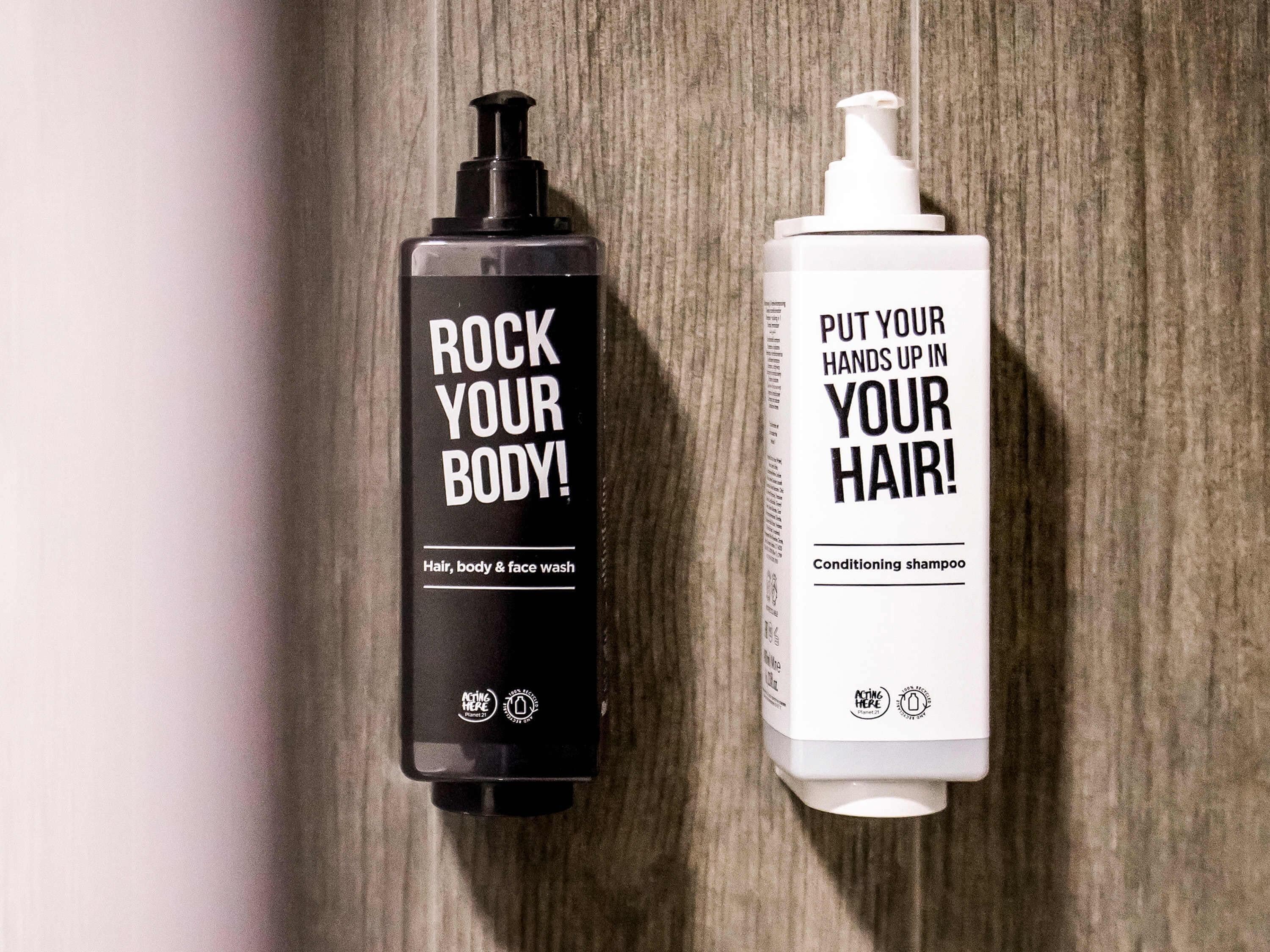 Two bottles of personal care products on a wooden surface.