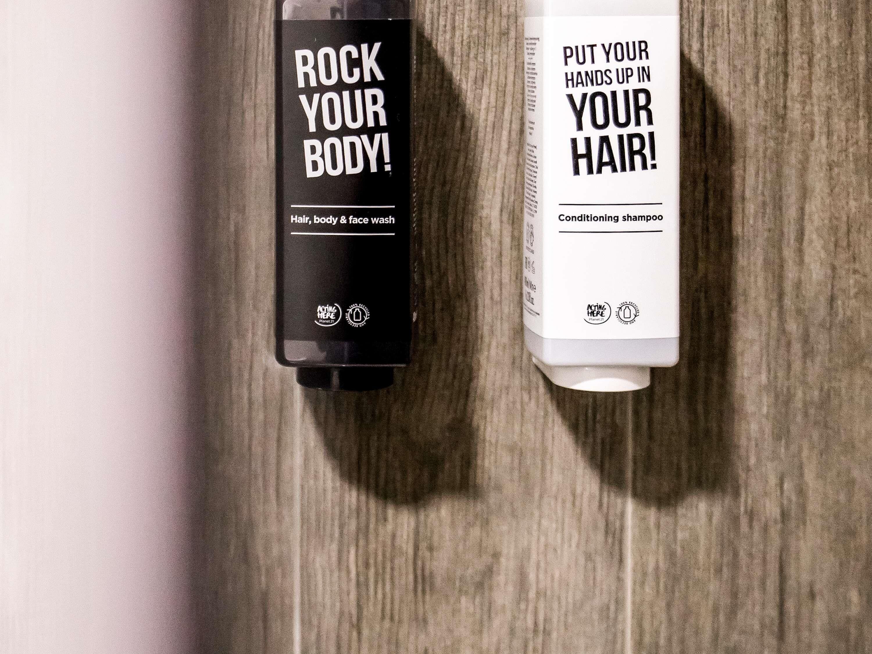 Two bottles of hair and body wash on a wooden surface.