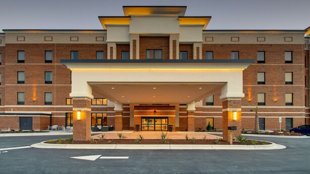 A multi-story hotel with a brick facade, a covered entrance, and a landscaped front area. - Hampton Inn Sneads Ferry North Topsail Beach (Sneads Ferry)