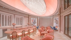 Amplia sala de estar elegantemente decorada, con barra central, asientos cómodos y grandes ventanales.