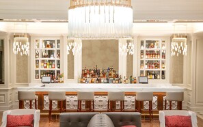 A bar area with a central seating arrangement, bar counters, and shelves of liquor bottles.