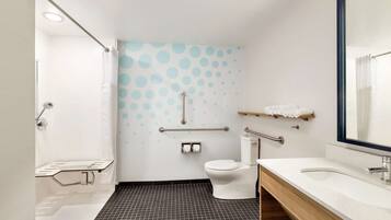 A modern bathroom with a shower, toilet, and sink.