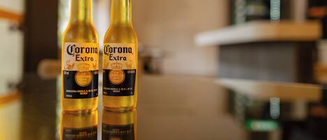 Deux bouteilles de bière Corona Extra posées sur une surface réfléchissante.