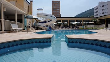 Alberca techada, alberca al aire libre y sombrillas en la alberca