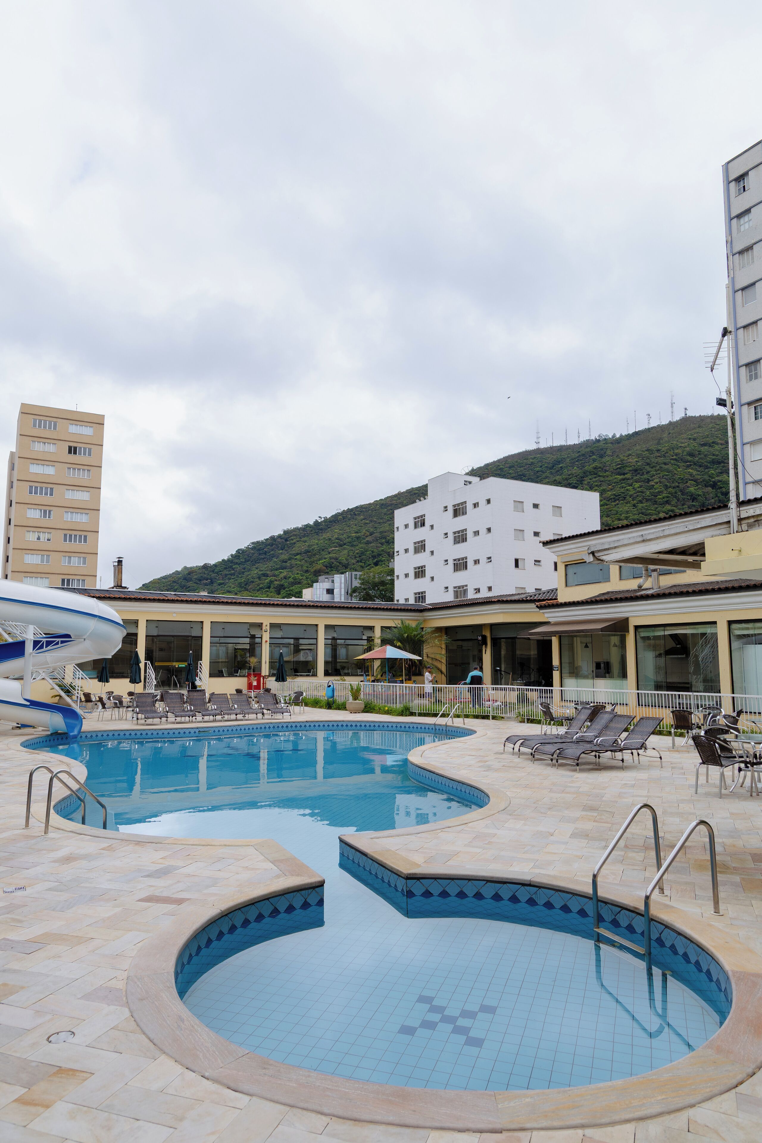 A swimming pool with lounge chairs and a building in the background.