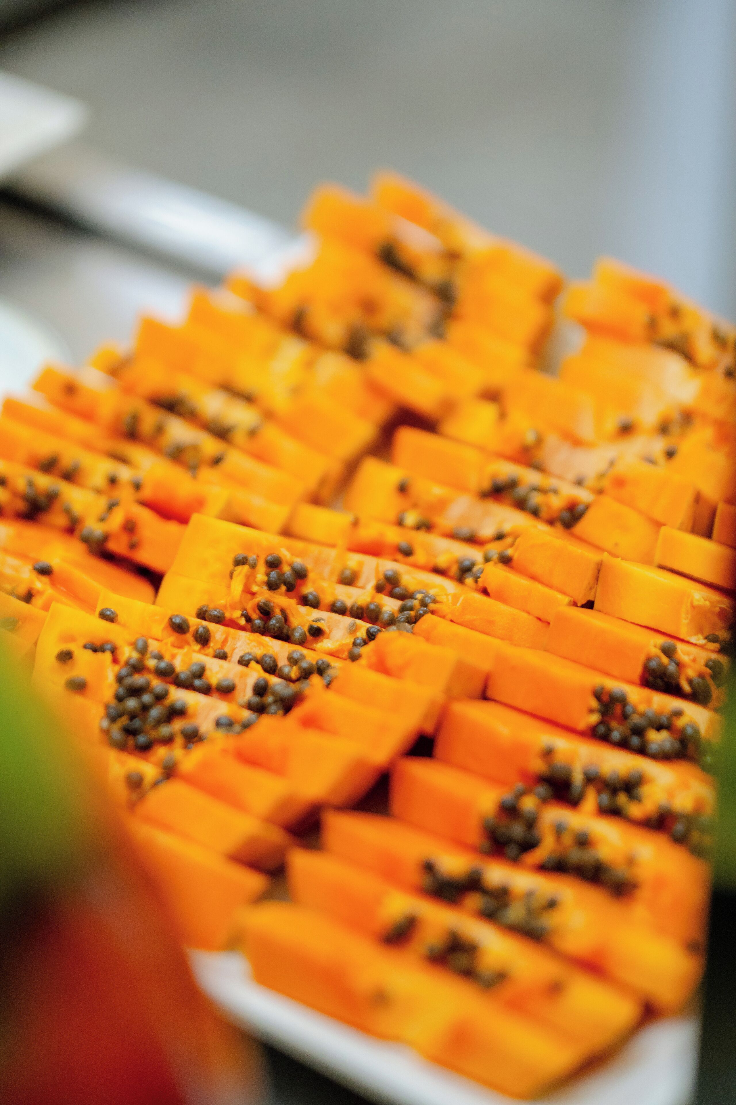 A close-up of sliced papaya arranged on a plate.