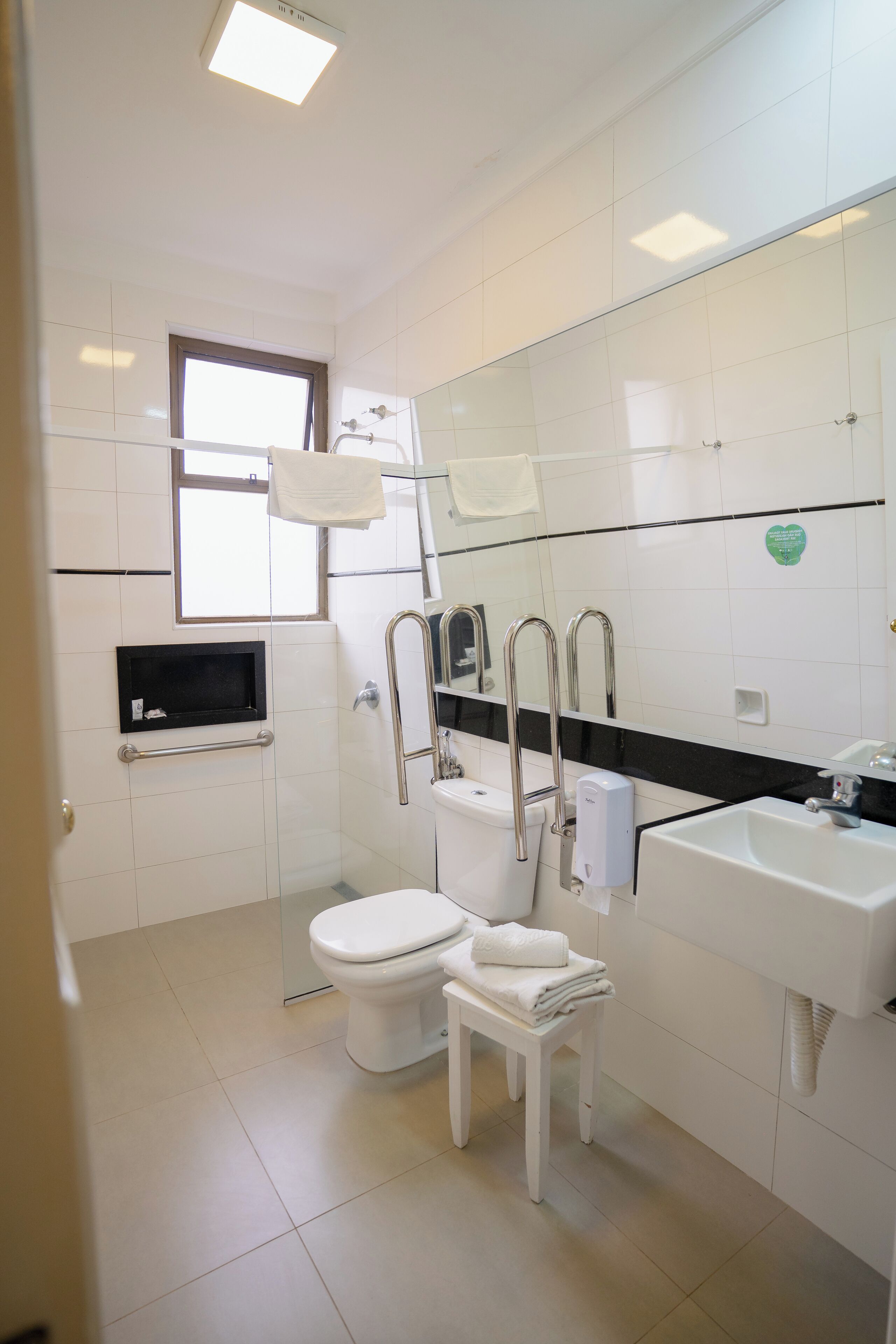Un baño moderno con inodoro, lavabo y cabina de ducha de vidrio.