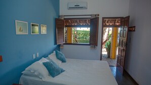 Un dormitorio con cama, ventana y puerta que da a un espacio exterior.