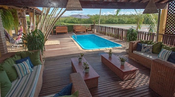 Una piscina al aire libre, sillones reclinables de piscina