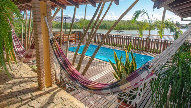 Una hamaca, una piscina y vistas a un lago.
