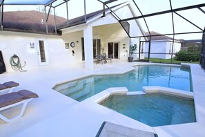 A swimming pool with lounge chairs and a covered patio area. - 360NHD (Davenport)