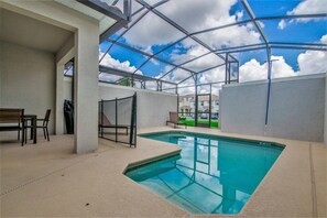 Una piscina interna con soffitto in vetro, una panchina e un tavolo.