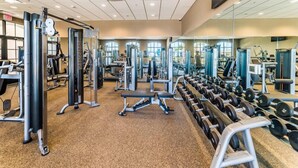 A gym with various exercise equipment, mirrors, and a carpeted floor. - HOME SWEET HOME (Kissimmee)