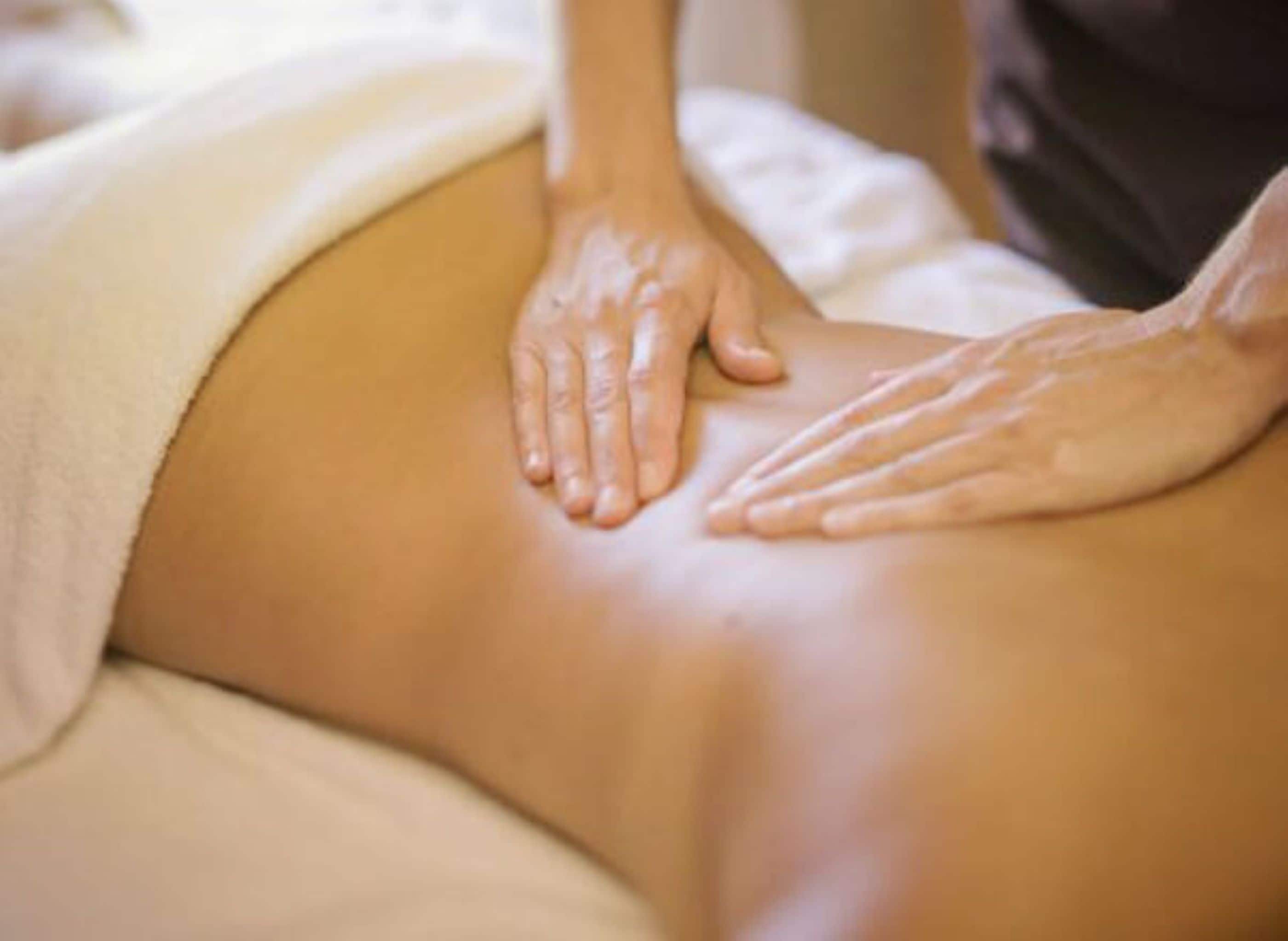 A person receiving a massage on a massage table.