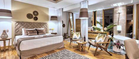A modern bedroom with a large bed, a ceiling fan, and a seating area with a coffee table and chairs.