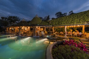 A resort with a hot tub area, outdoor seating, and a thatched-roof structure. - Origins Lodge (Bijagua)