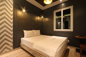 Un dormitorio con cama, ventana e iluminación en la pared.