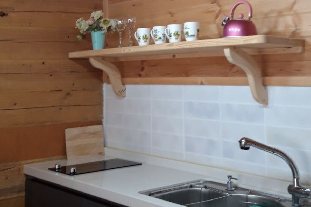 Een keuken met houten plafond, een gootsteen en een aanrecht.