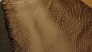 A bed with a brown patterned bedspread, a white pillow, and a wooden headboard. - Hotel New Park (Tokyo)