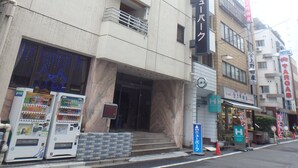 A building with a sign reading "Hotel" and a vending machine outside. - Hotel New Park (Tokyo)