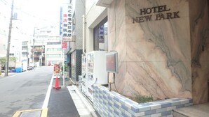 A hotel entrance with a marble facade and a sign reading "HOTEL NEW PARK". - Hotel New Park (Tokyo)