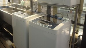 Two industrial drying machines in a warehouse with metal shelving and a metal roof. - Hotel SUNTARGAS UENO (Tokyo)