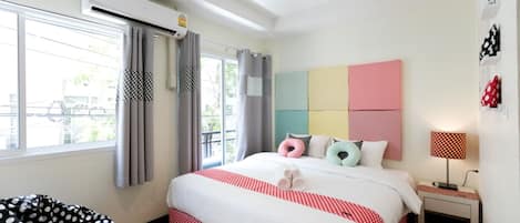 Une chambre à coucher moderne avec un grand lit, une table de chevet, une lampe et une fenêtre avec des rideaux.