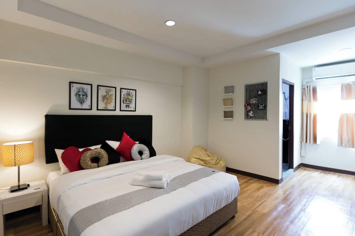 Une chambre d’hôtel moderne avec un grand lit, une lampe de chevet et des œuvres d’art accrochées au mur.