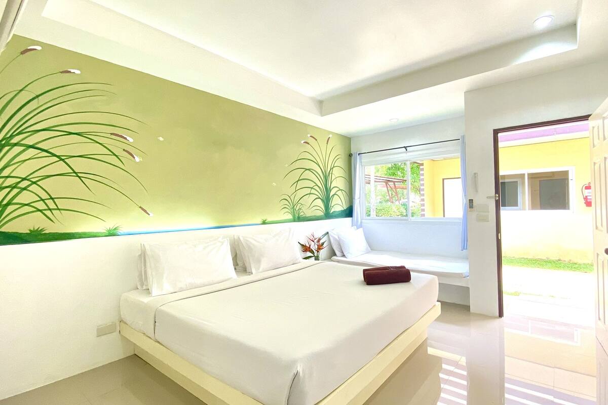 A bedroom with a bed, a window, and a door leading to an outdoor area.