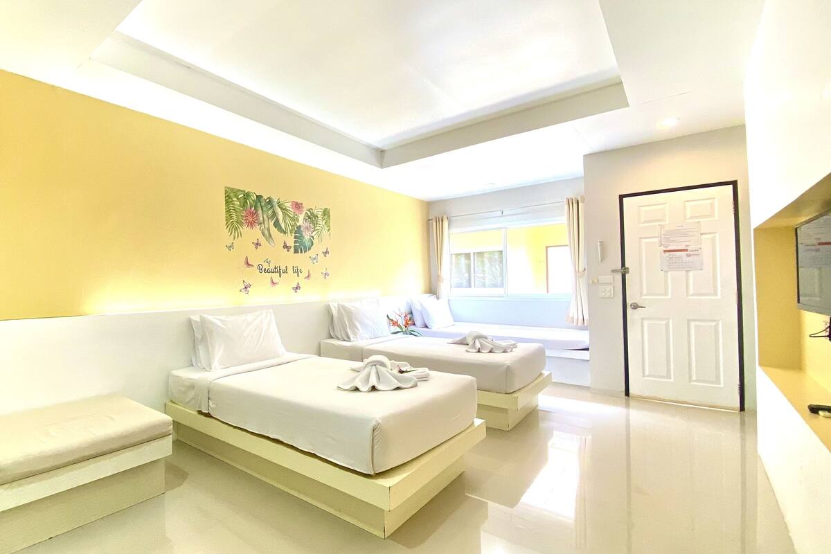 A modern hotel room with a bed, a sofa, and a desk.