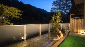 A swimming pool with a view of a mountain, a bamboo structure, and a wooden fence. - Ooedo Onsen Monogatari Unazuki Grand Hotel (Kurobe)