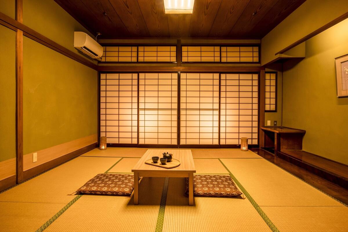 Une pièce de style japonais traditionnel, avec un sol recouvert de tatamis, une petite table en bois et des paravents en papier de riz (shoji).