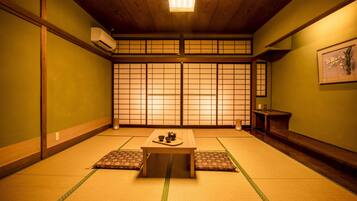 A traditional Japanese room with tatami flooring, a low wooden table, and shoji screens.
