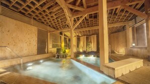 A wooden spa with two hot tubs, wooden beams, and a tiled floor. - Ooedo Onsen Monogatari Unazuki Grand Hotel (Kurobe)