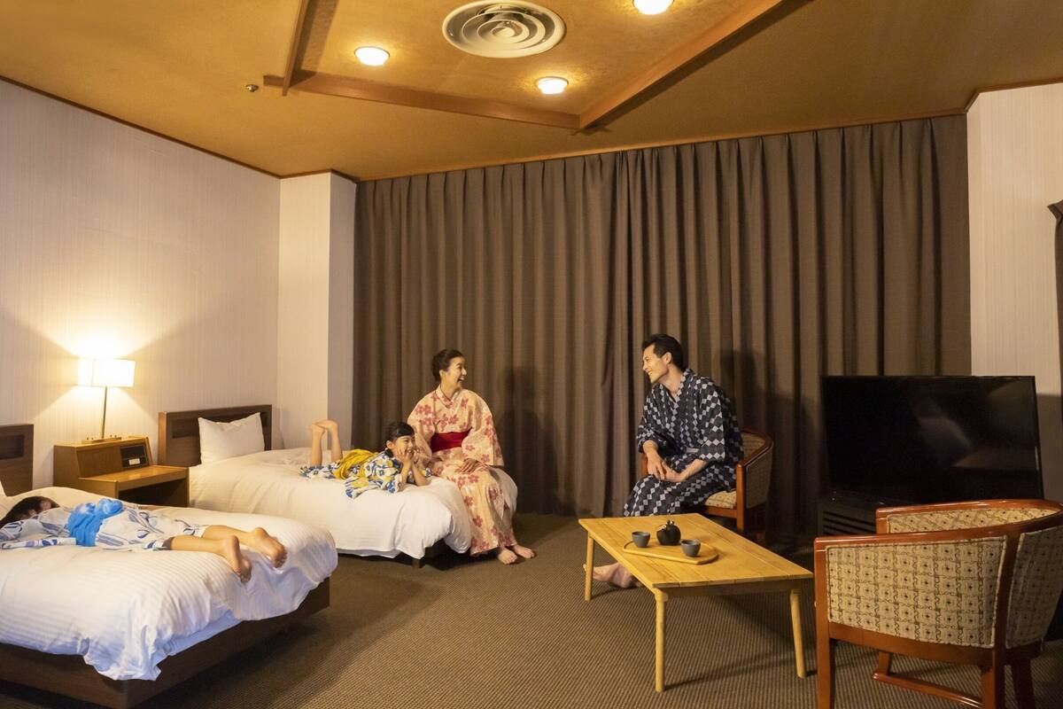 Une chambre d’hôtel avec deux lits, une télévision et une petite table.