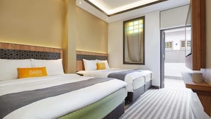 Habitación de hotel con dos camas, un ventanal grande y vistas al exterior.