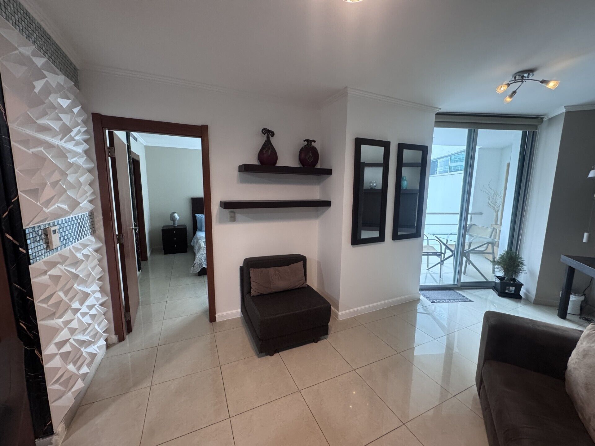 A spacious living area with a sofa, a fireplace, and a view of the outdoors.