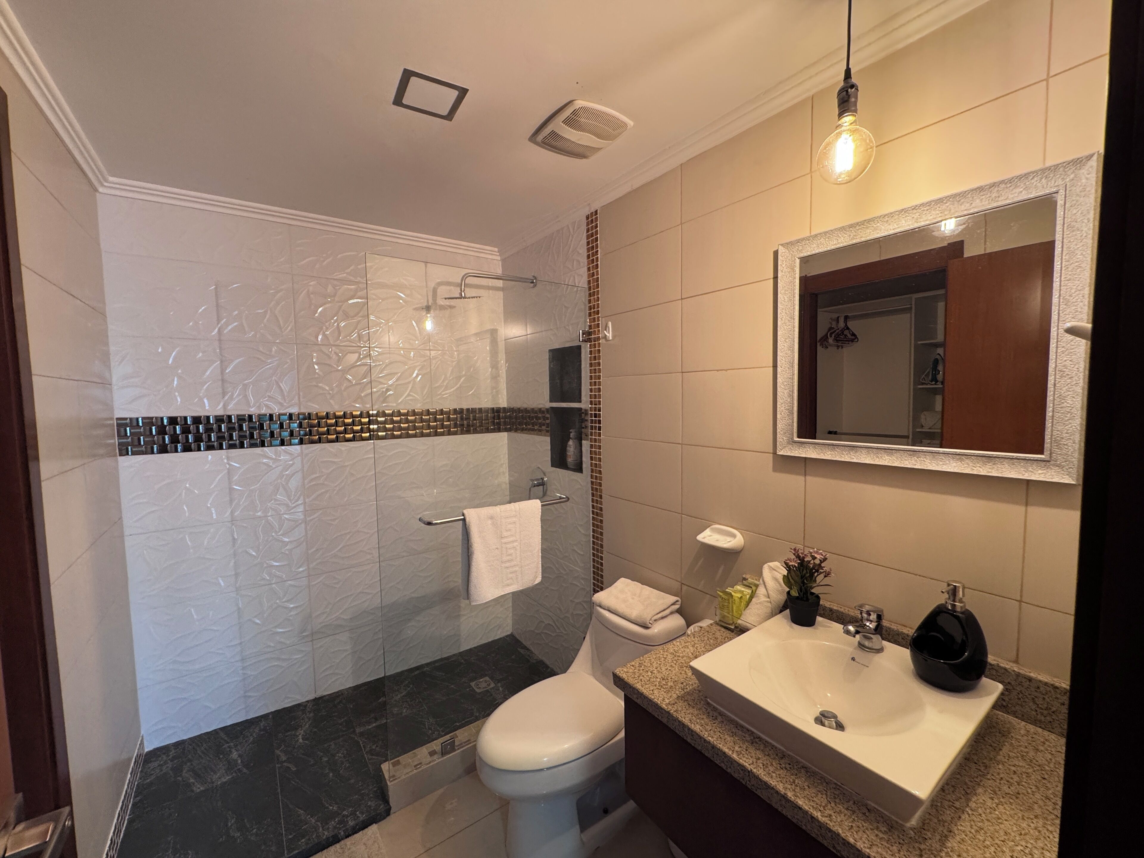 Une salle de bain comprenant des toilettes, un lavabo et un espace douche.