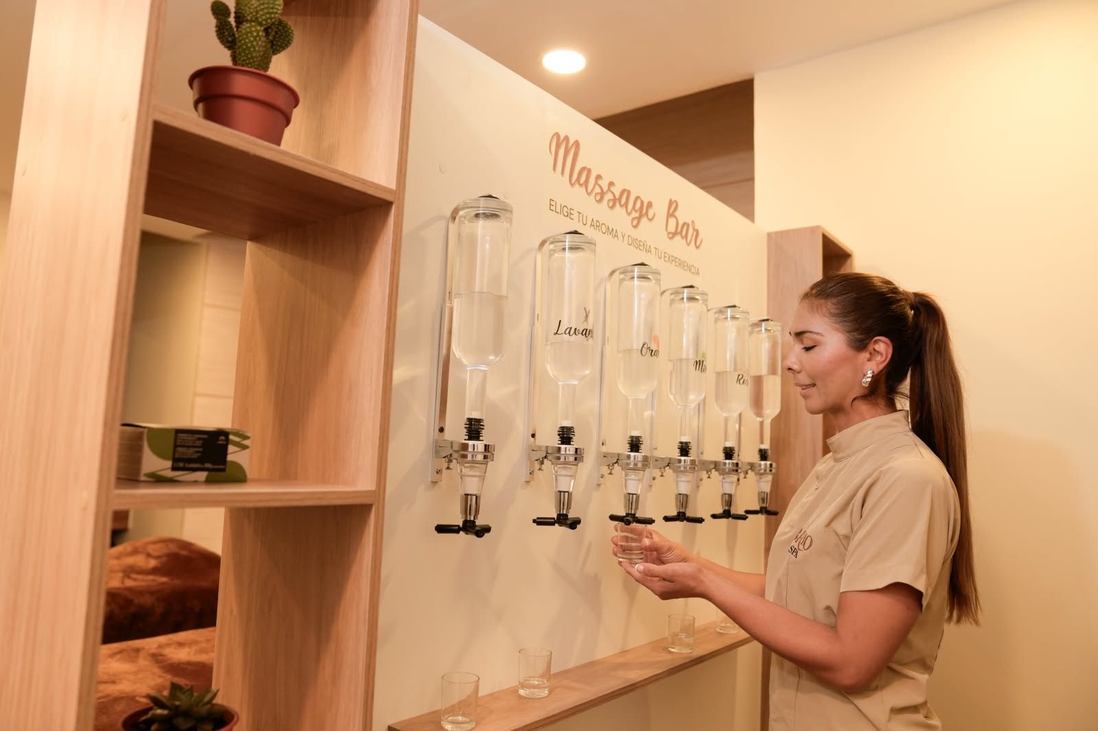 A person at a massage bar with multiple dispensers labeled with different scents.