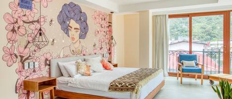 A bedroom with a large bed, a nightstand, a chair, and a balcony with a view.